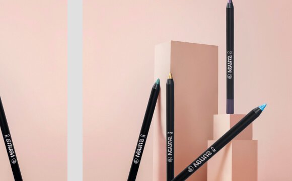 Színes szemceruzák elegáns elrendezésben rózsaszín háttér előtt.